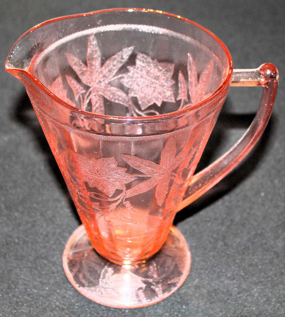 Up for sale is this Elegant Jeannette Floral Pink Footed Pitcher in excellent condition with no chips or cracks. The Pitcher measures approx. 7 1/2"T and holds 32 ounces.  Circa 1932-1935Shipping Excludes: Alaska/Hawaii, US Protectorates, APO/FPO, P